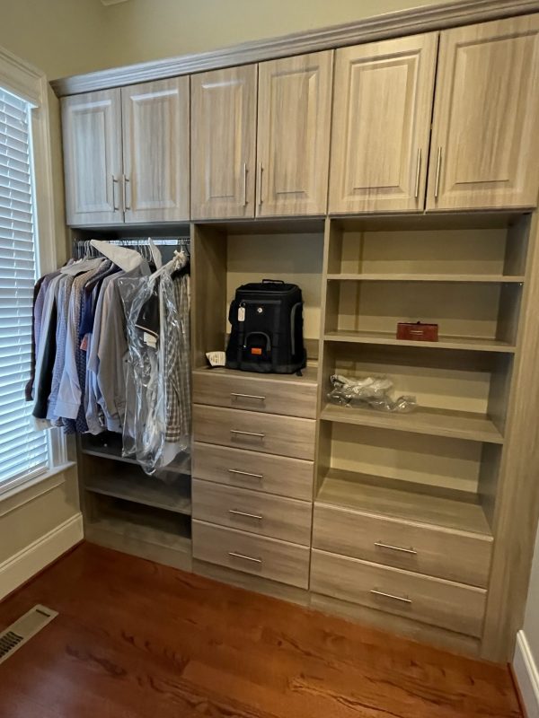 A well-organized closet filled with a variety of clothes and shoes neatly arranged in a room.