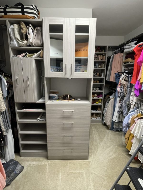 A walk-in closet filled with various clothes and accessories neatly organized on shelves and hangers.