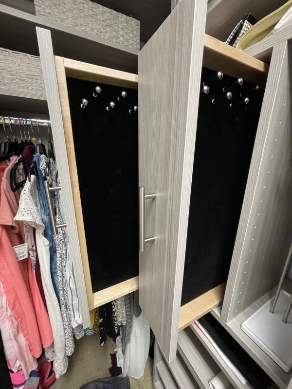 A neatly organized closet with drawers and various clothes neatly folded and hung inside.