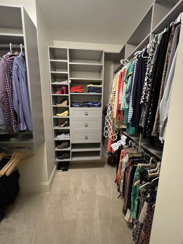 A cluttered closet filled with clothes, shoes, and miscellaneous items.