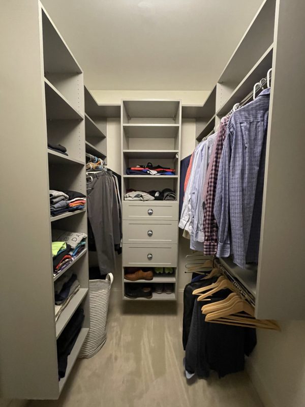 A cluttered closet filled with clothes, shoes, and various items neatly arranged on shelves and hangers.