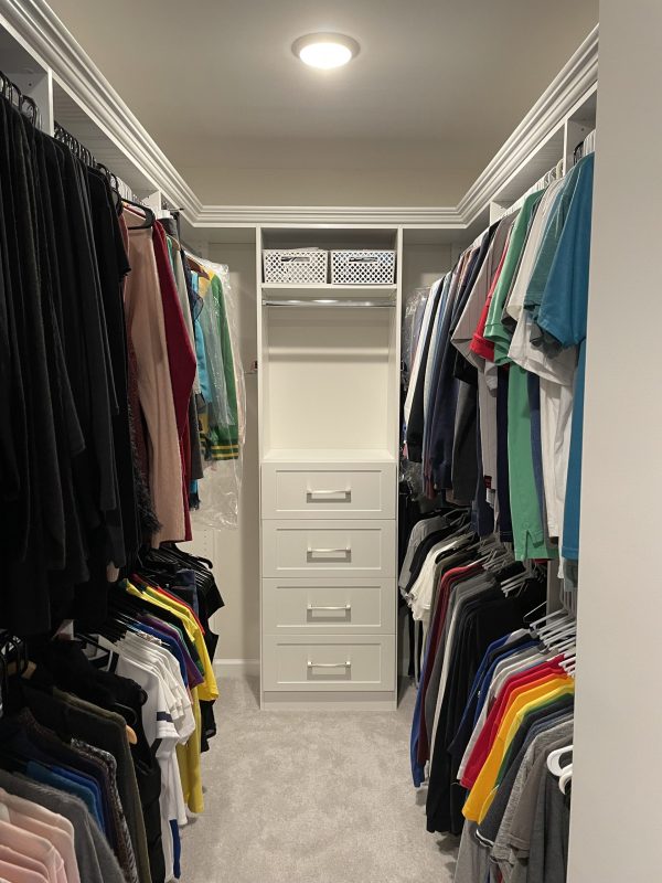 A neatly organized closet with various clothes and shoes neatly arranged on shelves.