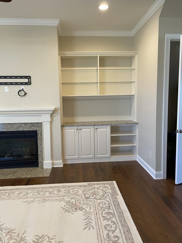 A cozy living room with a fireplace and a built-in bookcase, perfect for relaxing and reading by the fire.